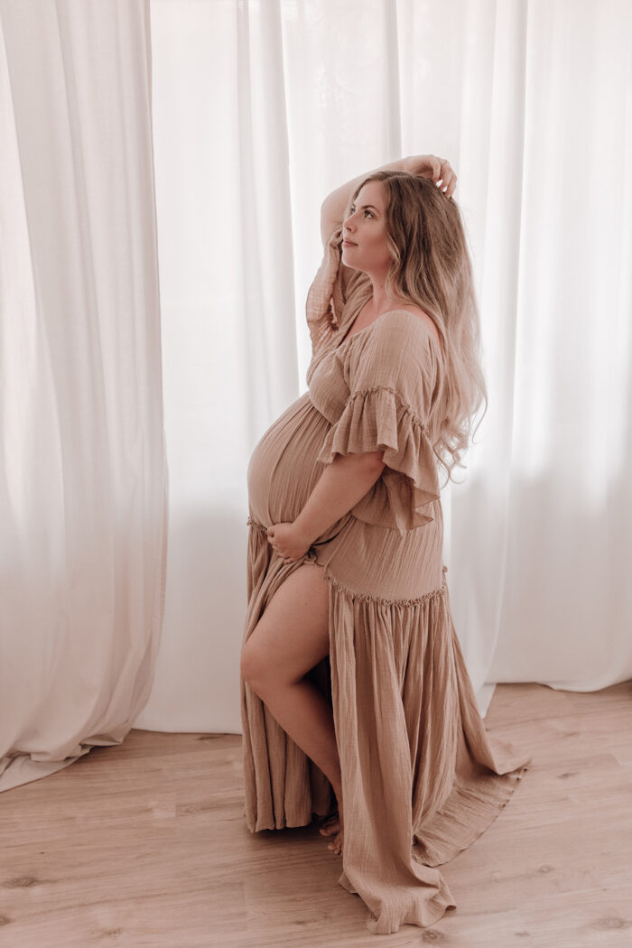 Schwangere Frau fotografiert von einfallslicht fotografie bei Babybauch Shooting in Düsseldorf inklusive Schwangerschaftskleidung im Tageslichtstudio in Düsseldorf