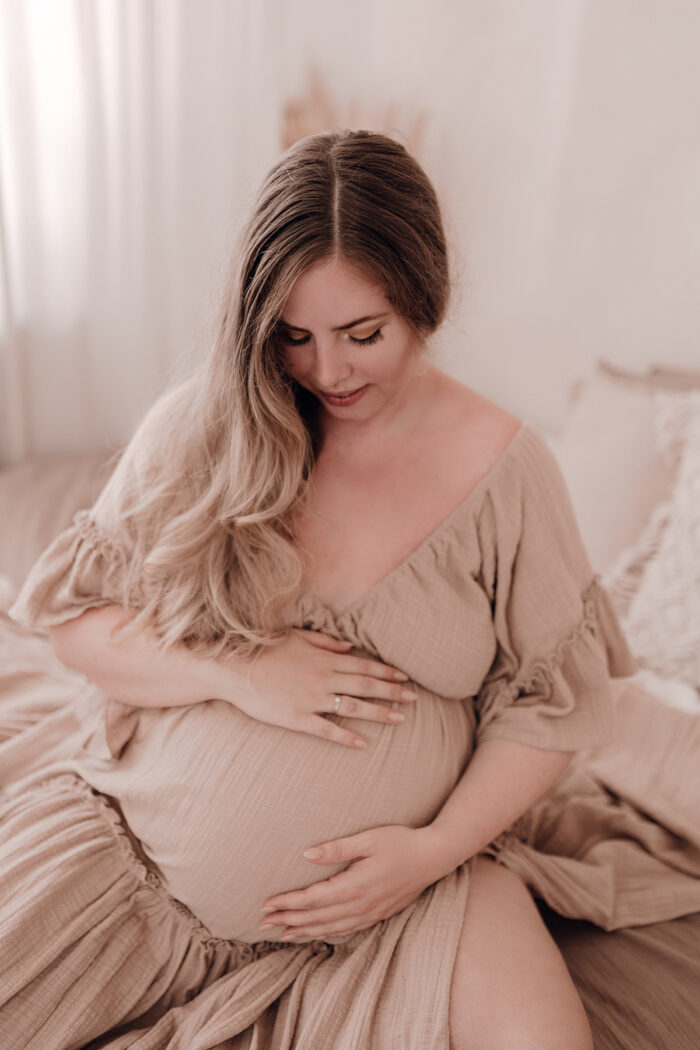 Schwangere Frau fotografiert von einfallslicht fotografie bei Babybauch Shooting in Düsseldorf inklusive Schwangerschaftskleidung im Tageslichtstudio in Düsseldorf