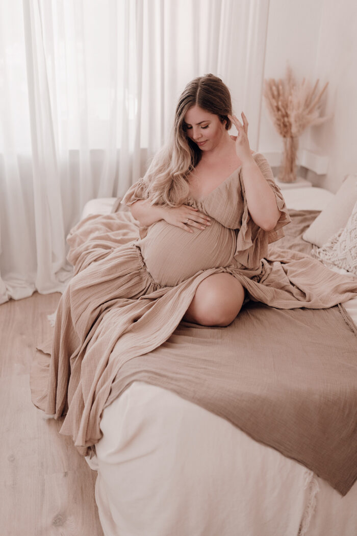 Schwangere Frau fotografiert von einfallslicht fotografie bei Babybauch Shooting in Düsseldorf inklusive Schwangerschaftskleidung im Tageslichtstudio in Düsseldorf