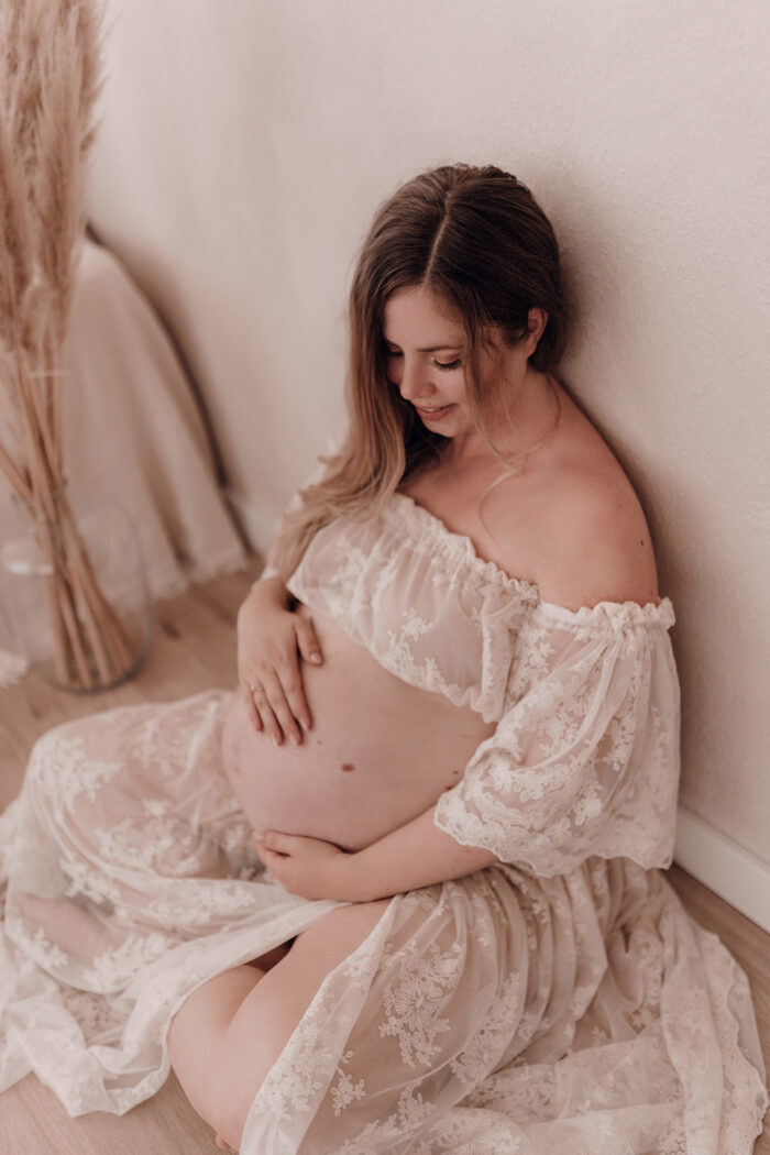 Schwangere Frau fotografiert von einfallslicht fotografie bei Babybauch Shooting in Düsseldorf inklusive Schwangerschaftskleidung im Tageslichtstudio in Düsseldorf