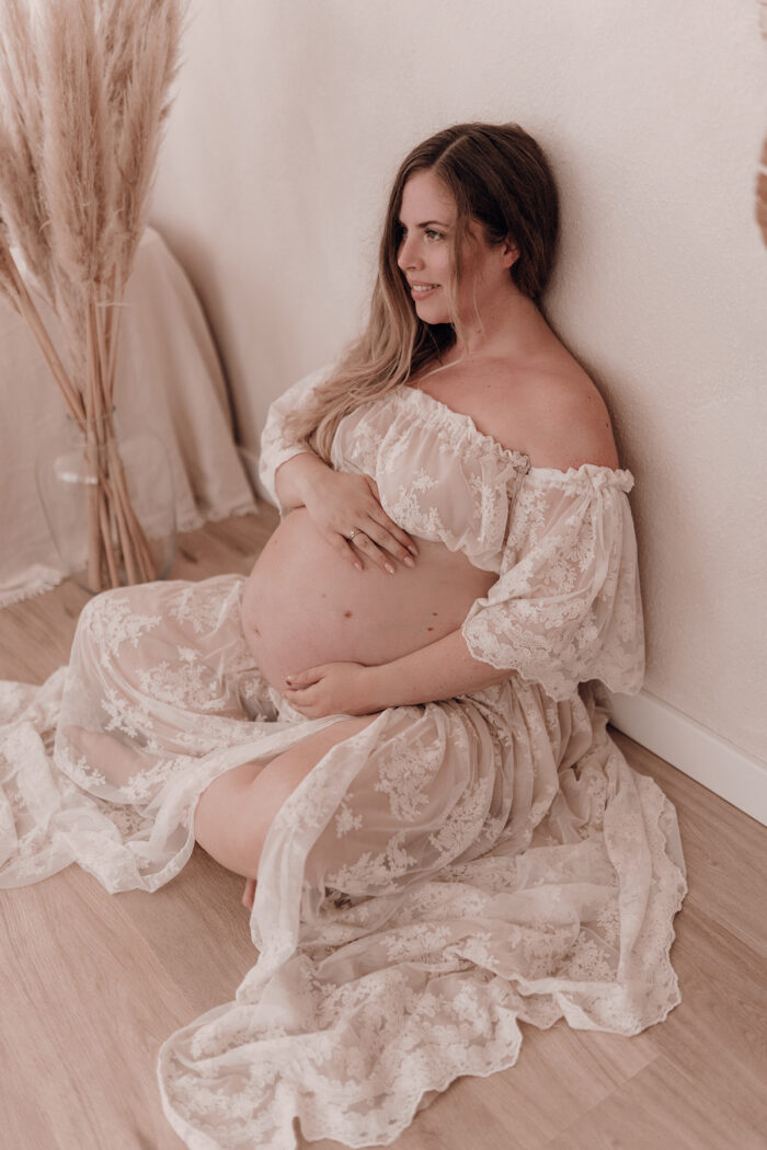 Schwangere Frau fotografiert von einfallslicht fotografie bei Babybauch Shooting in Düsseldorf inklusive Schwangerschaftskleidung im Tageslichtstudio in Düsseldorf