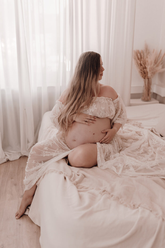 Schwangere Frau fotografiert von einfallslicht fotografie bei Babybauch Shooting in Düsseldorf inklusive Schwangerschaftskleidung im Tageslichtstudio in Düsseldorf