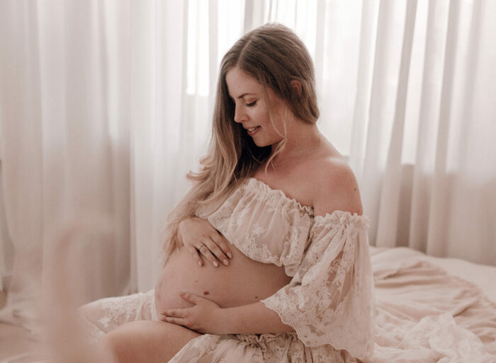 Schwangere Frau fotografiert von einfallslicht fotografie bei Babybauch Shooting in Düsseldorf inklusive Schwangerschaftskleidung im Tageslichtstudio in Düsseldorf