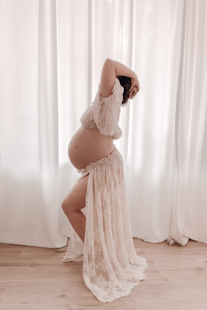 Schwangere Frau fotografiert von einfallslicht fotografie bei Babybauch Shooting in Düsseldorf inklusive Schwangerschaftskleidung im Tageslichtstudio in Düsseldorf