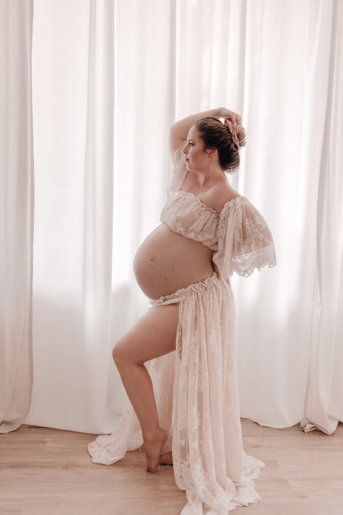 Schwangere Frau fotografiert von einfallslicht fotografie bei Babybauch Shooting in Düsseldorf inklusive Schwangerschaftskleidung im Tageslichtstudio in Düsseldorf