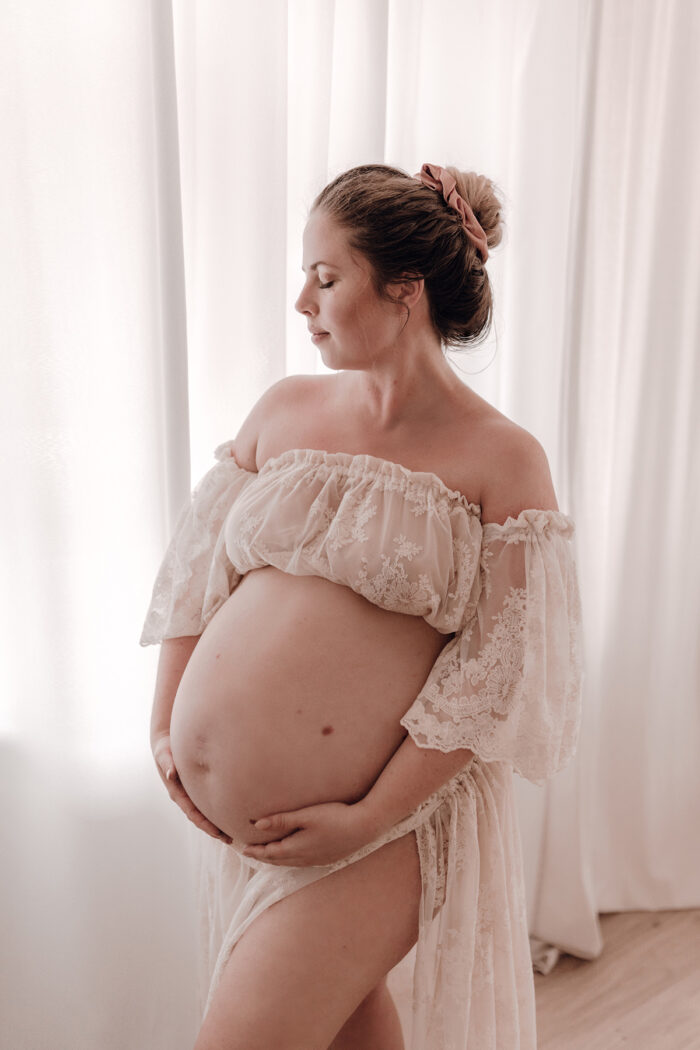Schwangere Frau fotografiert von einfallslicht fotografie bei Babybauch Shooting in Düsseldorf inklusive Schwangerschaftskleidung im Tageslichtstudio in Düsseldorf