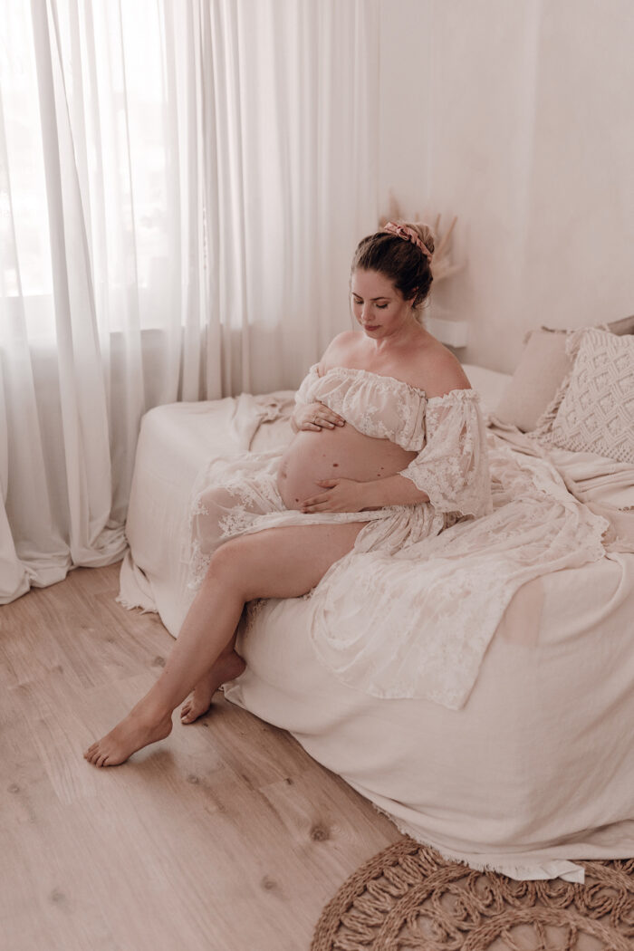 Schwangere Frau fotografiert von einfallslicht fotografie bei Babybauch Shooting in Düsseldorf inklusive Schwangerschaftskleidung im Tageslichtstudio in Düsseldorf