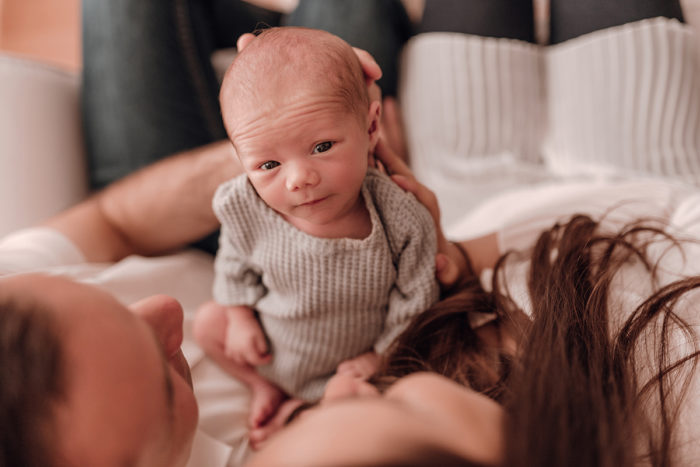 Baby guckt in die Kamera von einfallslicht fotografie beim Neugeborenen Shooting in Düsseldorf