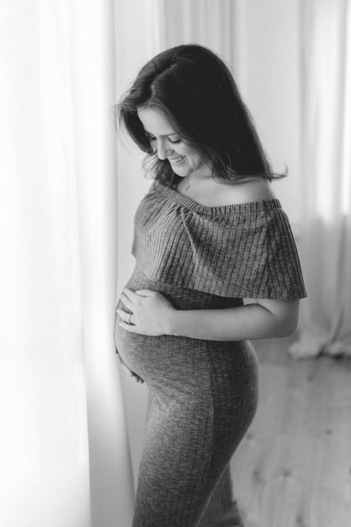 Mama streichelt Babybauch Babybauchfotos im Studio Babybauchsession Duesseldorf Babyfotos Babyfotografin Düsseldorf Umstandkleid Schwangerschaftskleid