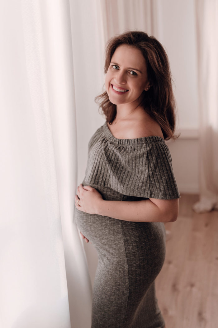 Mama streichelt Babybauch Babybauchfotos im Studio Babybauchsession Duesseldorf Babyfotos Babyfotografin Düsseldorf Umstandkleid Schwangerschaftskleid