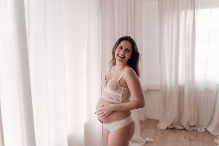 Mama streichelt Babybauch Babybauchfotos im Studio Babybauchsession Duesseldorf Babyfotos Babyfotografin Düsseldorf Umstandkleid Schwangerschaftskleid