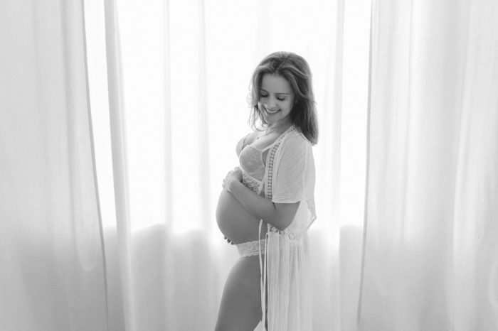 Mama streichelt Babybauch Babybauchfotos im Studio Babybauchsession Duesseldorf Babyfotos Babyfotografin Düsseldorf Umstandkleid Schwangerschaftskleid