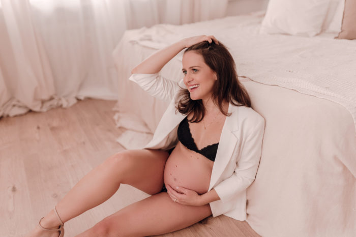 Mama streichelt Babybauch Babybauchfotos im Studio Babybauchsession Duesseldorf Babyfotos Babyfotografin Düsseldorf Umstandkleid Schwangerschaftskleid