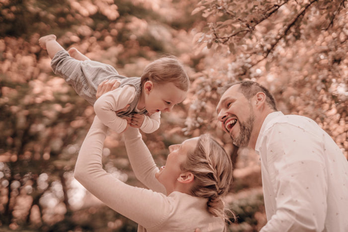 Baby mit Eltern im Park mit Babyfotografin einfallslicht fotografie Familie Mama Papa lachen Familienfoto Familienbilder Babyfotos