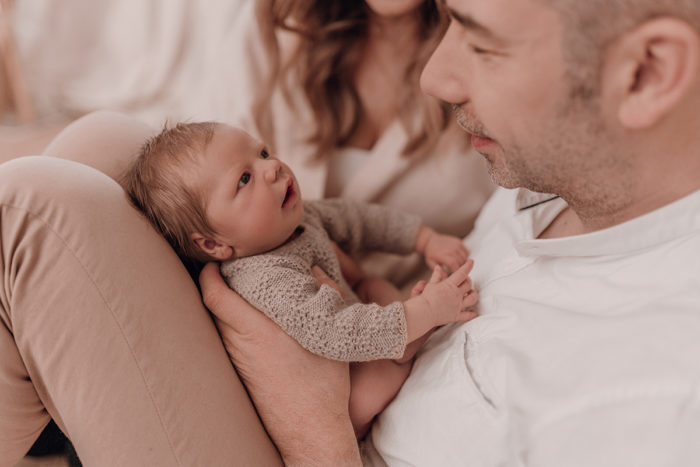 Eltern mit Baby beim Neugeborenen Shooting, Geschwisterliebe, Familienshooting bei einfallslicht fotografie in Düsseldorf, Baby, Babykleidung, Babybody