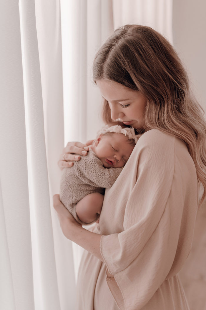 Mama kuschelt beim Neugeborenen Shooting, Geschwisterliebe, Familienshooting bei einfallslicht fotografie in Düsseldorf, Baby, Babykleidung, Babybody