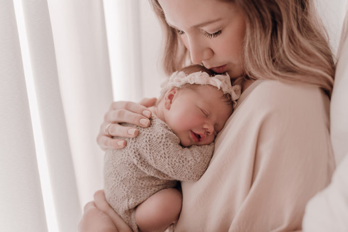 Mama kuschelt beim Neugeborenen Shooting, Geschwisterliebe, Familienshooting bei einfallslicht fotografie in Düsseldorf, Baby, Babykleidung, Babybody