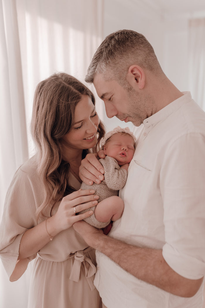 Familie kuschelt beim Neugeborenen Shooting, Geschwisterliebe, Familienshooting bei einfallslicht fotografie in Düsseldorf, Baby, Babykleidung, Babybody