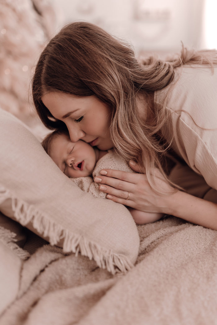 Mama kuschelt beim Neugeborenen Shooting, Geschwisterliebe, Familienshooting bei einfallslicht fotografie in Düsseldorf, Baby, Babykleidung, Babybody