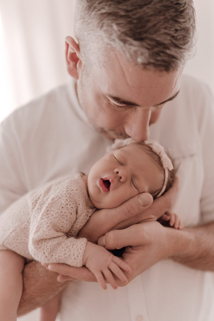 Papa kuschelt beim Neugeborenen Shooting, Geschwisterliebe, Familienshooting bei einfallslicht fotografie in Düsseldorf, Baby, Babykleidung, Babybody