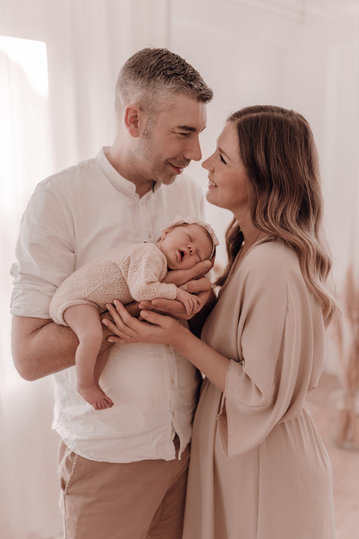 Familie kuschelt beim Neugeborenen Shooting, Geschwisterliebe, Familienshooting bei einfallslicht fotografie in Düsseldorf, Baby, Babykleidung, Babybody